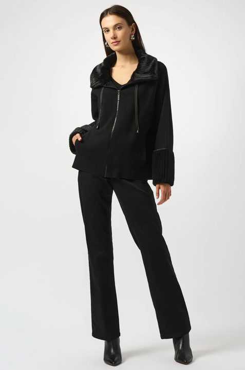 Woman wearing a black outfit with a jacket and pants on a white background